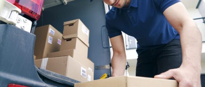 courier-unloading-packages-on-the-hand-truck-768x512